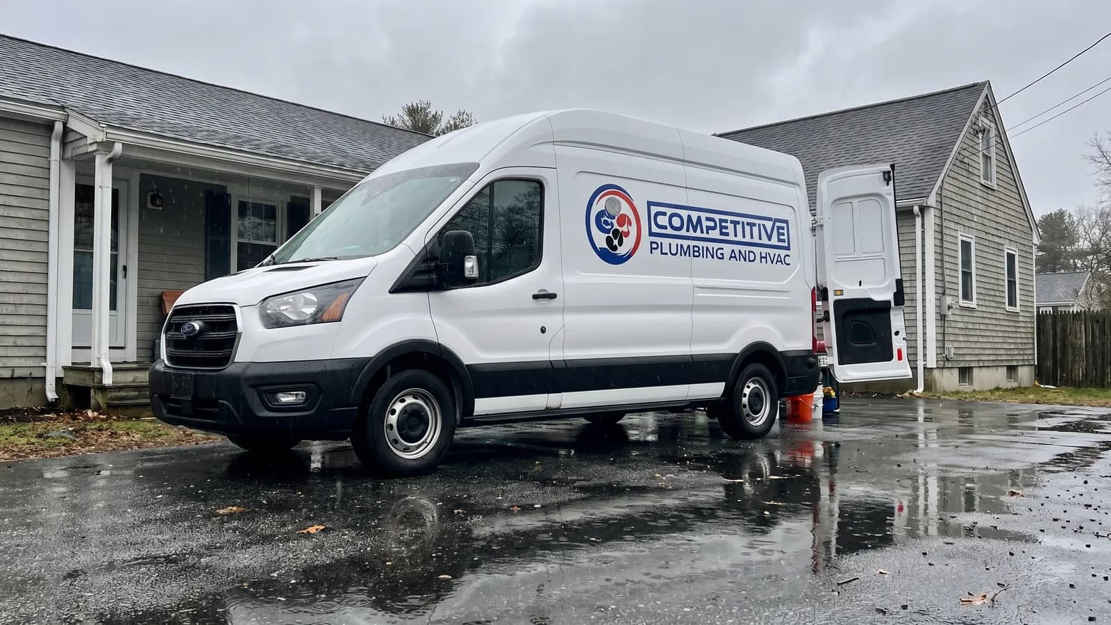 Competitive Plumbing & HVAC emergency service van arriving at a Massachusetts home after a plumbing leak call