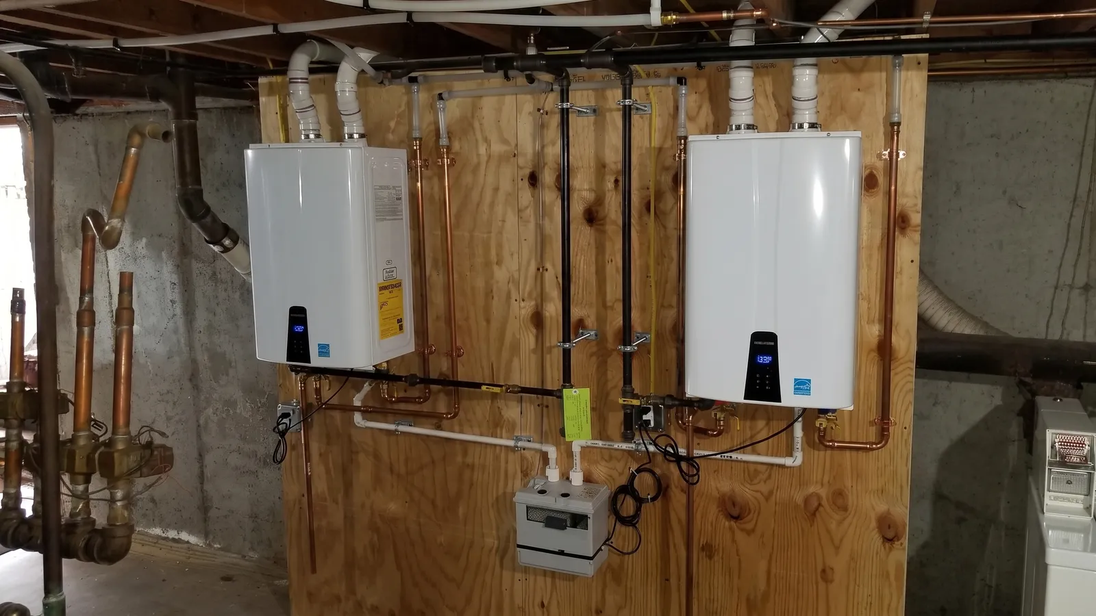Twin wall-hung tankless water heaters with copper piping installed by Competitive Plumbing & HVAC in Massachusetts